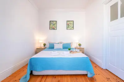 a bedroom with a blue and white bed and two lamps at Host Wise - Spacious Comfortable Apartment - Balcony in Porto