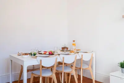 a white dining room table with chairs and food on it at Host Wise - Spacious Comfortable Apartment - Balcony in Porto