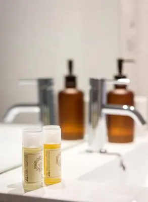 two bottles of soap sitting on a bathroom sink at DA'HOME - Boavista Blue Studio - NEW in Porto