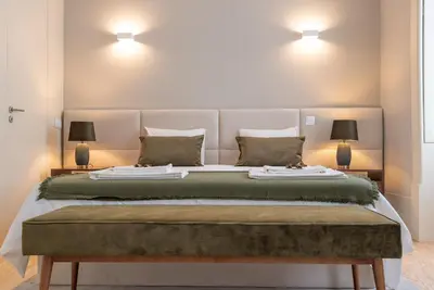 a bedroom with a large bed with two lamps at CC Downtown Palace - F in Porto
