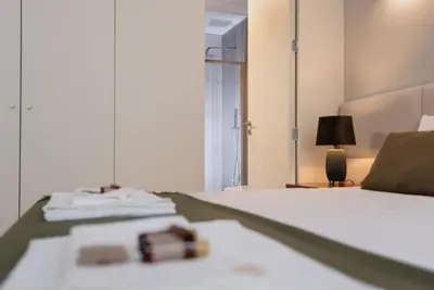 a bedroom with a white bed with a mirror at CC Downtown Palace - F in Porto