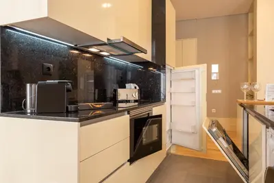 a kitchen with white cabinets and black counter tops at CC Downtown Palace - F in Porto