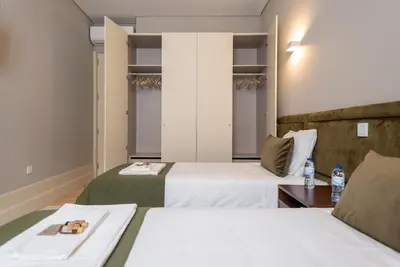 a hotel room with two beds and a table at CC Downtown Palace - F in Porto