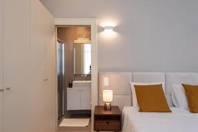 a bedroom with a bed and a bathroom with a mirror at CC Downtown Palace - G in Porto