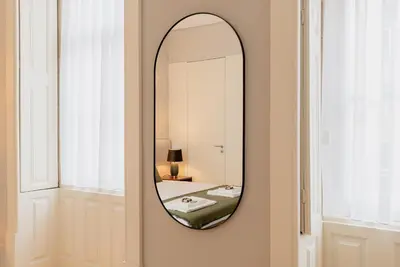 a mirror hanging on a wall in a room at CC Downtown Palace - H in Porto