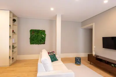 a living room with a white couch and a tv at CC Downtown Palace - H in Porto