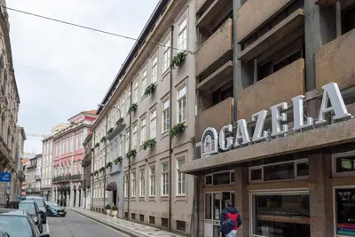 a building with a sign on it on a city street at CC Downtown Palace - I in Porto