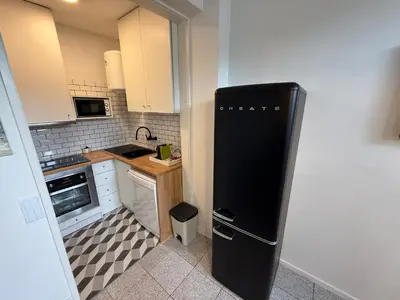 a small kitchen with a black refrigerator in it at SantOporto Clérigos in Porto