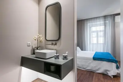 a bathroom with a sink and a bed and a mirror at GuestReady - Jardim das Oliveiras GuestHouse in Porto