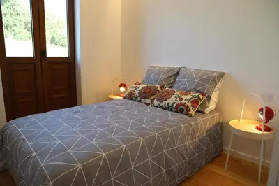 a bedroom with a bed with a blue comforter at Casa do Pilar - D Maria Pia in Vila Nova de Gaia