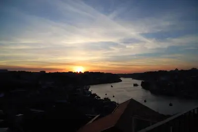a view of a river with the sunset in the background at Casa do Pilar - D Maria Pia in Vila Nova de Gaia
