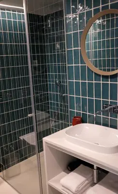 a bathroom with a sink and a shower with a mirror at Adega Floresta Residence in Porto