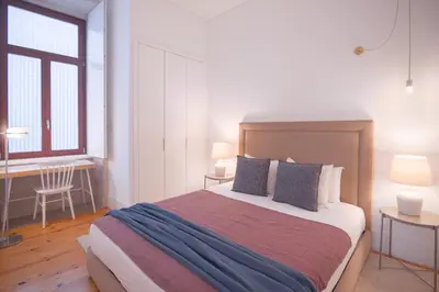a bedroom with a bed and a desk and a window at Bolhão - Dixo's Oporto Apartments VIII in Porto