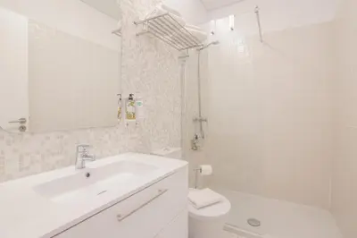 a white bathroom with a sink and a toilet at Bolhão - Dixo's Oporto Apartments VIII in Porto
