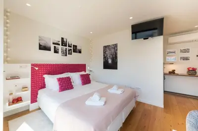 a bedroom with a large bed with a pink headboard at LovelyStay - Heart of D. Pedro Apartments IV in Porto