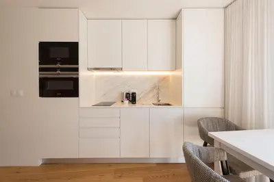 a kitchen with white cabinets and a sink at LovelyStay - Heart of D. Pedro Apartments IV in Porto