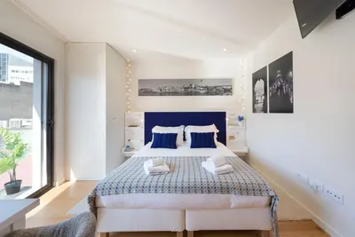 a bedroom with a bed and a large window at LovelyStay - Heart of D. Pedro Apartments IV in Porto