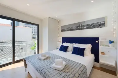 a bedroom with a large bed and a large window at LovelyStay - Heart of D. Pedro Apartments IV in Porto