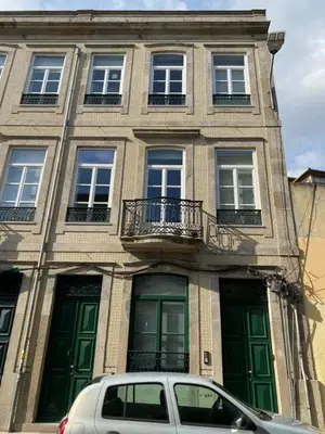 a car parked in front of a building with green doors at Villa Invicta in Porto