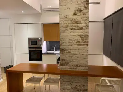 a kitchen with a wooden table and some chairs at Palace House Apartment in Porto
