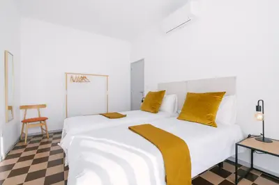 a bedroom with a large white bed with yellow pillows at D&S - Family Apartments I in Porto