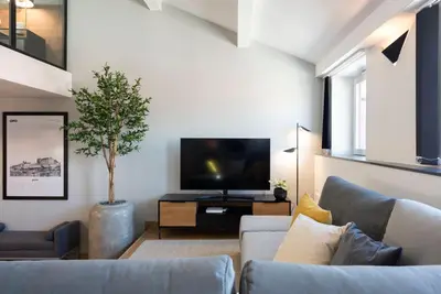 a living room with a couch and a tv at Modern Loft with AC in Downtown Porto by LovelyStay in Porto