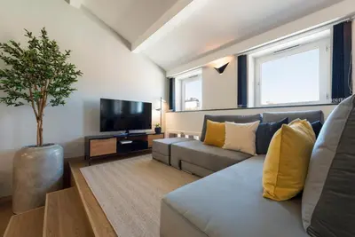 a living room with a couch and a tv at Modern Loft with AC in Downtown Porto by LovelyStay in Porto