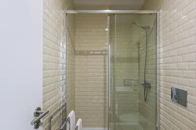 a shower with a glass door in a bathroom at GuestReady - The Art of Music in Porto