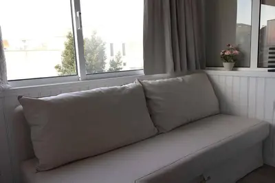 a couch with pillows sitting in front of a window at Romantic Getaway Suite in Porto
