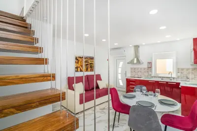 a kitchen with a table and red chairs in a room at Maredimo Village Casa 3 in Porto