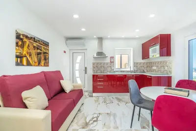 a living room with a red couch and a table at Maredimo Village Casa 3 in Porto