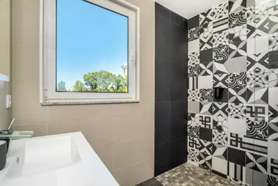 a bathroom with a black and white tile wall at Maredimo Village Casa 3 in Porto