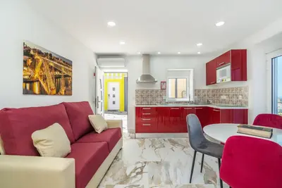 a living room with a red couch and a table at Maredimo Village Casa 3 in Porto