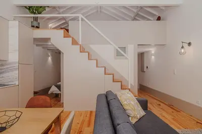 a living room with a couch and a staircase at Oporto Artist´s Loft in Porto