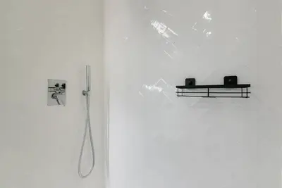 a shower in a white room with a wall at GuestReady - Three Mirrors in Porto
