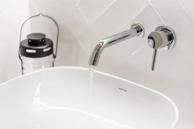 a sink with water coming out of a faucet at GuestReady - Three Mirrors in Porto