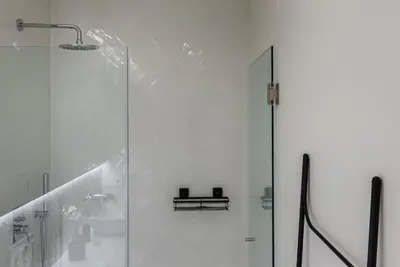 a white bathroom with a shower and a sink at GuestReady - Three Mirrors in Porto