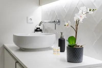 a bathroom with a bowl sink and flowers on a counter at GuestReady - Three Mirrors in Porto