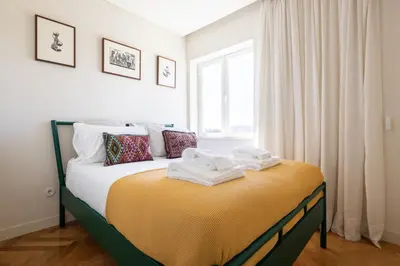 a bedroom with a bed with towels on it at Best rooftop in Porto! in Porto