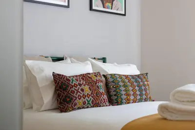 a white bed with four pillows on it at Best rooftop in Porto! in Porto