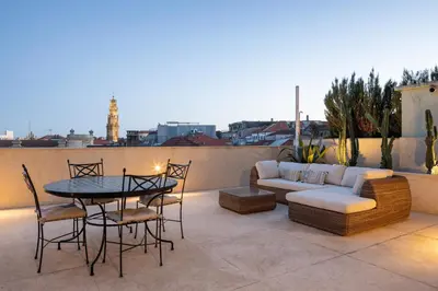 a patio with a couch and a table and chairs at Best rooftop in Porto! in Porto