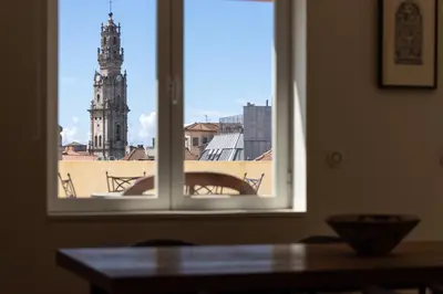 a window with a view of a clock tower at Best rooftop in Porto! in Porto