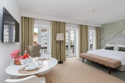 a hotel room with a bed and a table and chairs at Casa de Arouca Porto Apartments in Porto