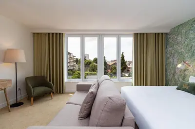a bedroom with a bed and a couch and a window at Casa de Arouca Porto Apartments in Porto
