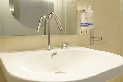 a white bathroom sink with a faucet and a mirror at The Bitcoin Chapel Iconic Luxury Residence in Porto