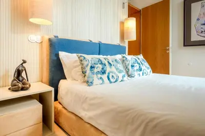 a bed with a blue headboard in a room at The Bitcoin Chapel Iconic Luxury Residence in Porto