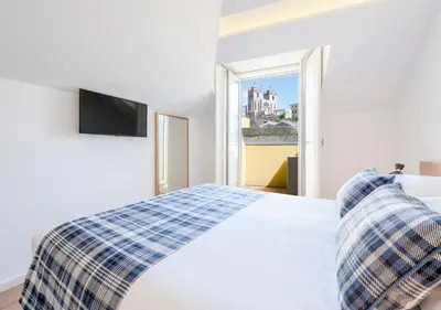 a white bedroom with a bed and a window at Mouzinho da Silveira Unique Apartments, by Oporto Collection in Porto