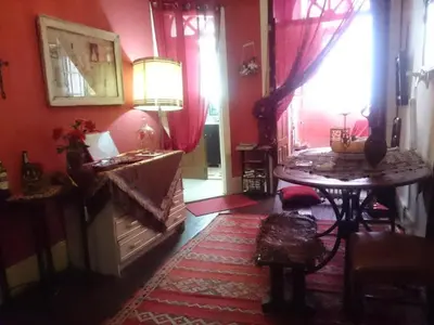 a living room with red walls and a table and a fireplace at AL-Almada-2 in Porto