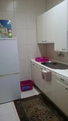 a kitchen with white cabinets and a sink and pink baskets at AL-Almada-2 in Porto