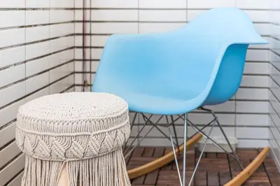 a blue chair and a stool in front of a wall at GuestReady - Red Stripes in Porto